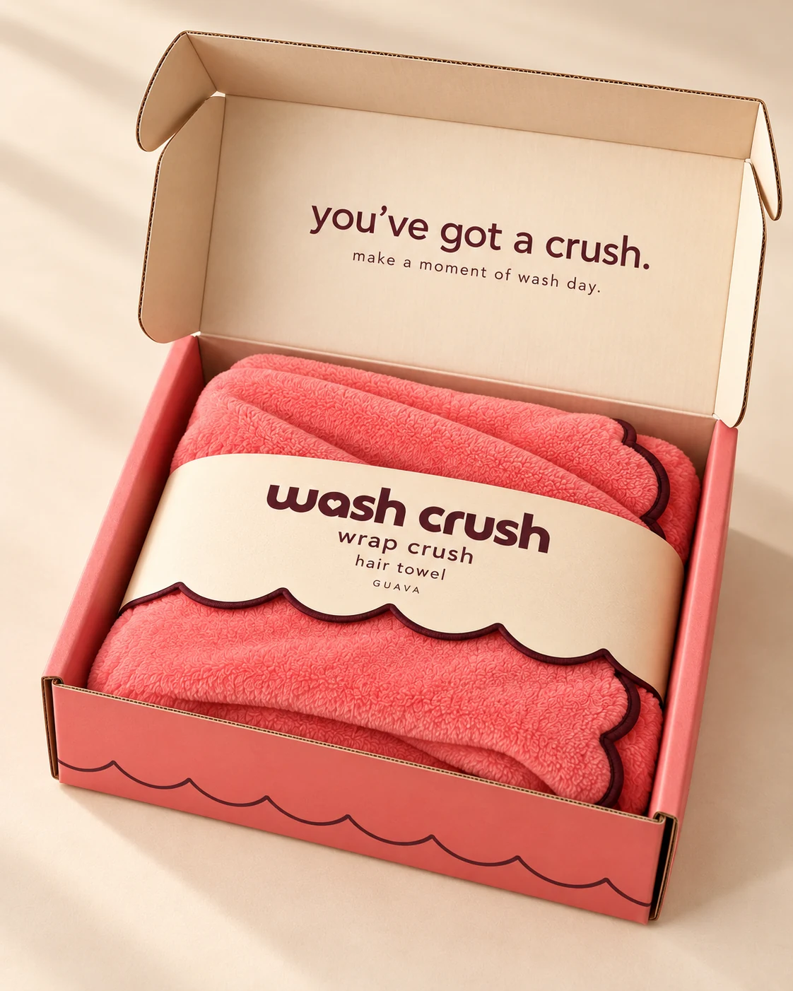 An open Guava Wash Crush box with a folded hair towel, scalloped cream sleeve and the message you’ve got a crush inside the lid